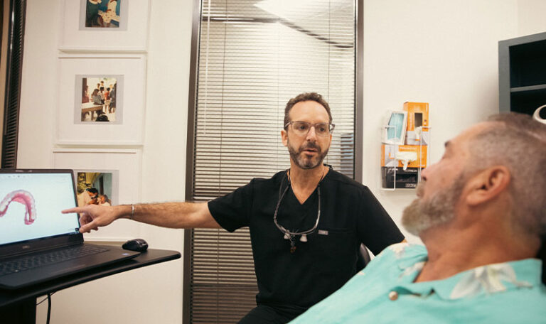 Dr. Friedberg discussing 3D dental scan results with a patient during a consultation