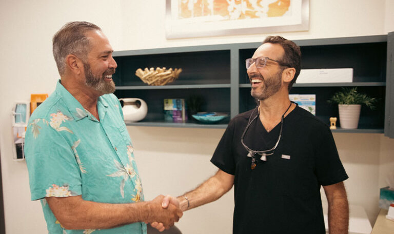 Dr. Friedberg greeting a happy patient at his Houston periodontal office