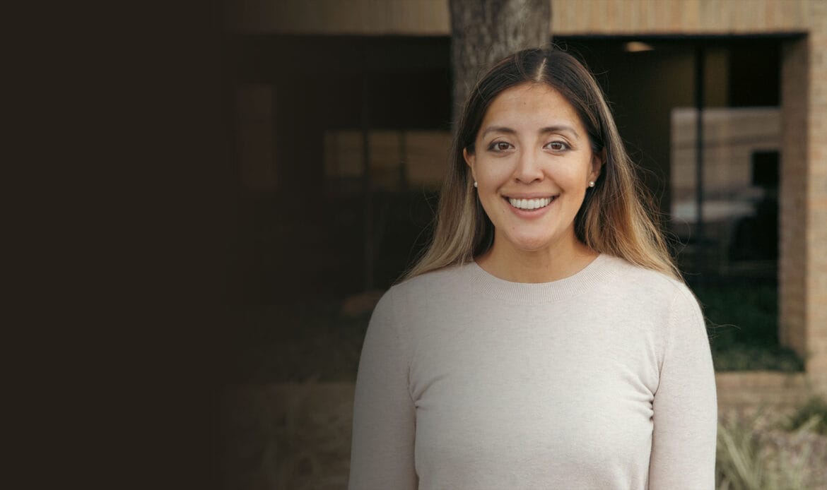 Smiling woman outside dental office representing patient satisfaction with gum grafting in Houston