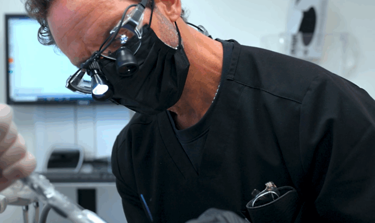 Dr. Friedberg wears proper medical safety gear as he performs a quick procedure on a patient.