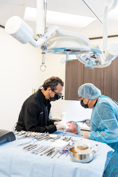 Periodontist performing gum surgery during a LANAP vs gum surgery treatment comparison