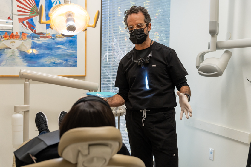 Periodontist explaining periodontal treatment to patient during consultation