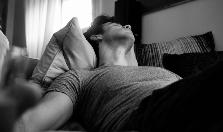 Man lying awake in bed struggling with untreated sleep apnea symptoms